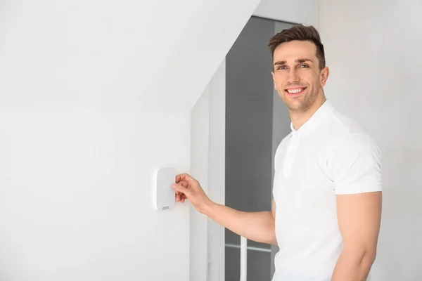 Young man using security system indoors — Stock Photo, Image