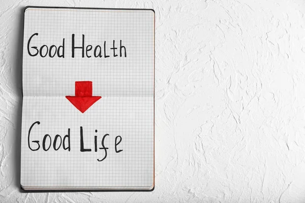 Phrase "Good health - good life" written in notebook on white background — Stock Photo, Image