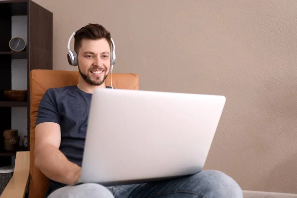 Freelancer with headphones using laptop at home — Stock Photo, Image