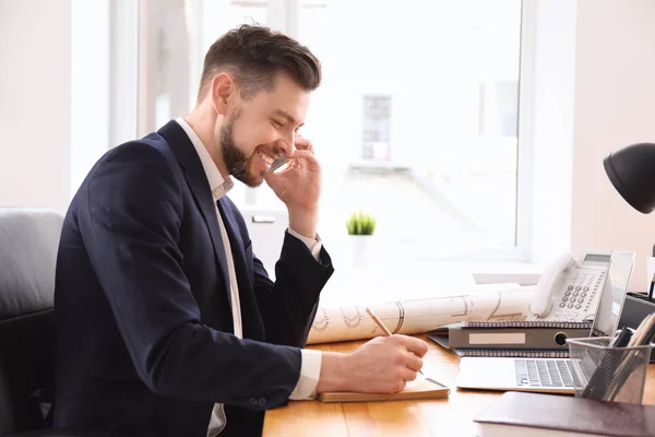 Businessman talking on phone while working in office — Stock Photo, Image