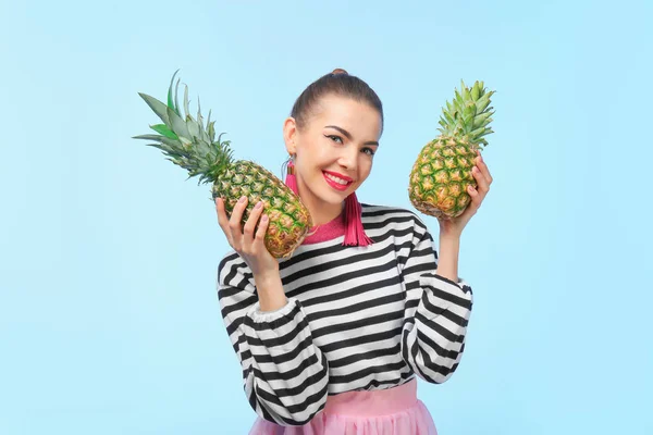 Attractive young woman with two pineapples on color background — Stock Photo, Image