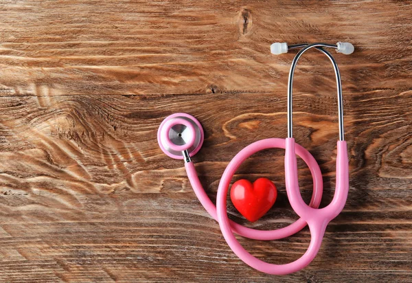 Estetoscopio y corazón rojo sobre fondo de madera. Concepto de salud —  Fotos de Stock