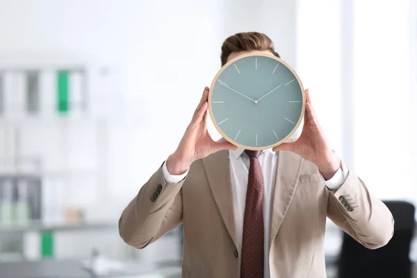 事務所の時計を持ったビジネスマン。時間管理の概念 — ストック写真