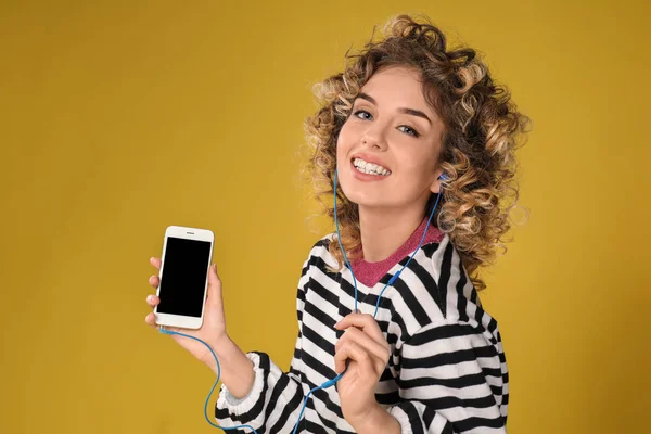 Portret van mooie jonge vrouw met mobiele telefoon luisteren naar muziek op de achtergrond kleur — Stockfoto