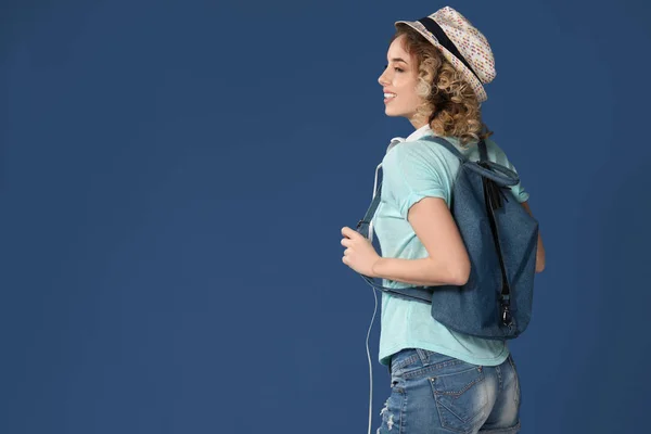 Vacker ung kvinna med ryggsäck på färgbakgrund — Stockfoto
