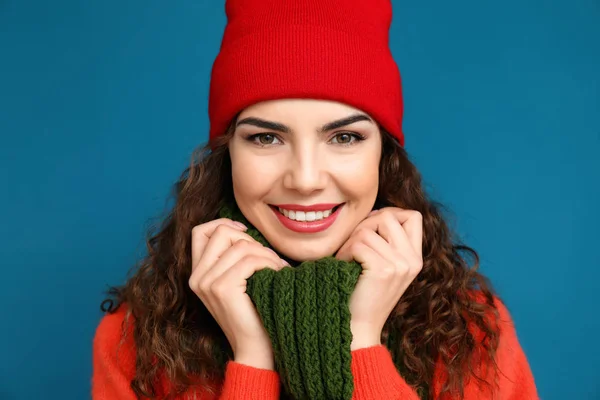 Portrait of beautiful young woman in warm clothes on color background — Stock Photo, Image