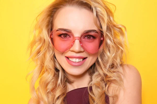 Portrait of beautiful young woman wearing sunglasses on color background — Stock Photo, Image