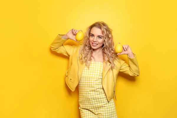 Ritratto di bella giovane donna con limoni su sfondo a colori — Foto Stock