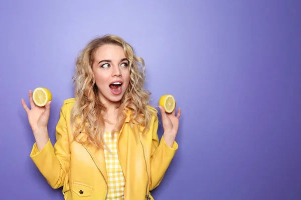 Porträt einer emotionalen jungen Frau mit Zitronen auf farbigem Hintergrund — Stockfoto