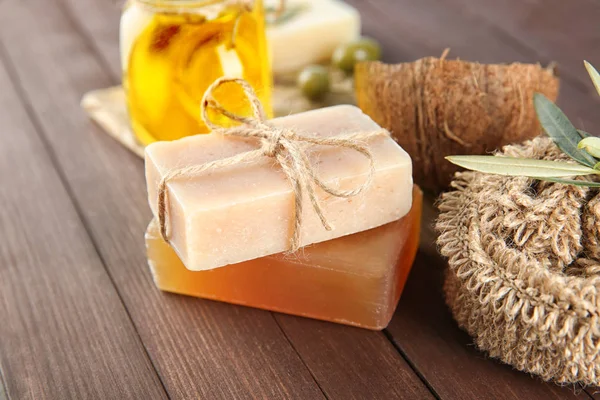 Bars of natural soap with olive extract on wooden table