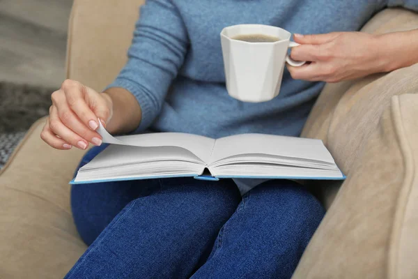 家で本を読みながらコーヒーを飲む若い女性 — ストック写真