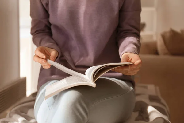 Jonge vrouw lezen van interessante boek thuis — Stockfoto