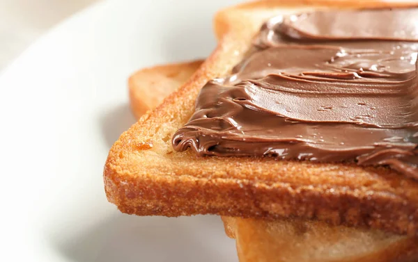 Delicious toasts with chocolate paste on plate, closeup — Stock Photo, Image