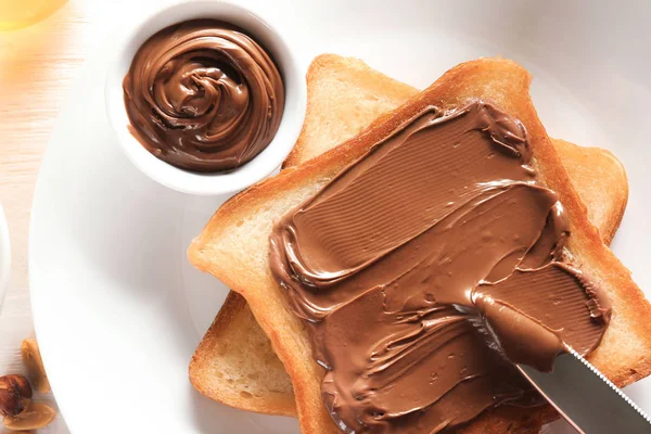 Delicious toasts with chocolate paste on plate