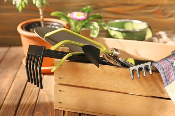 Caja de madera con herramientas de jardinería en la mesa — Foto de Stock