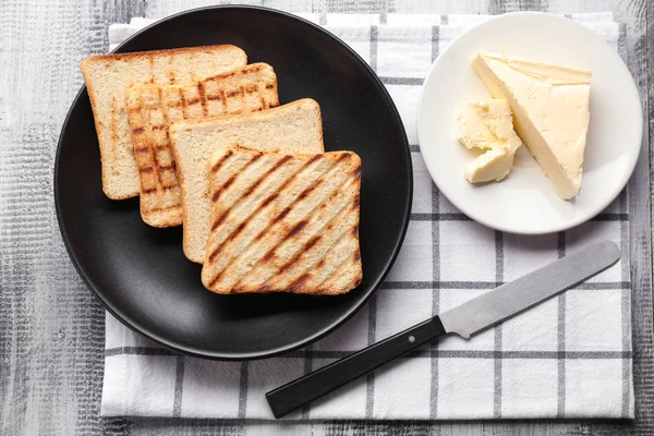 Pratos com pão torrado e manteiga na mesa — Fotografia de Stock