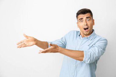 Işık arka plan üzerinde şok genç adam