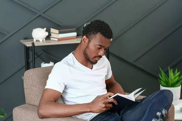 Hombre afroamericano guapo leyendo libro en casa — Foto de Stock