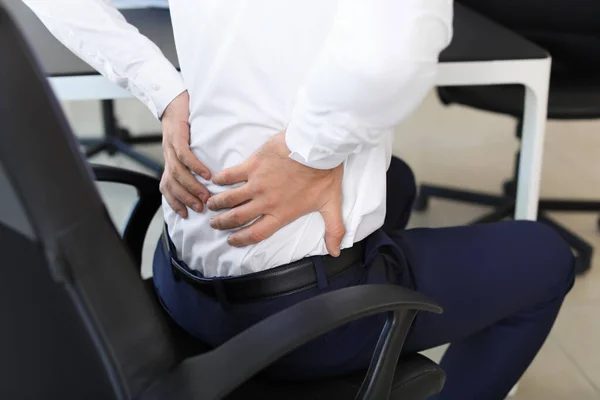 Молодий чоловік страждає від болю в спині в офісі — стокове фото