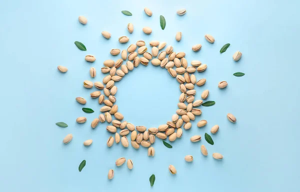 Frame made of tasty pistachio nuts on color background — Stock Photo, Image