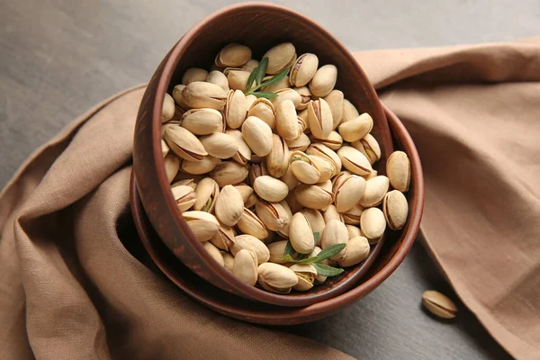 Bowls with tasty pistachio nuts on table — Stock Photo, Image