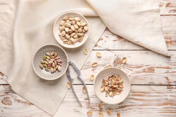 Tasty pistachio nuts with nutcracker on table — Stock Photo, Image