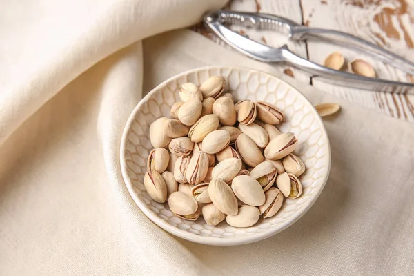 Plate with tasty pistachio nuts on table — Stock Photo, Image