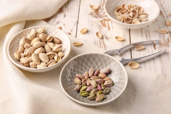 Tasty pistachio nuts with nutcracker on table — Stock Photo, Image