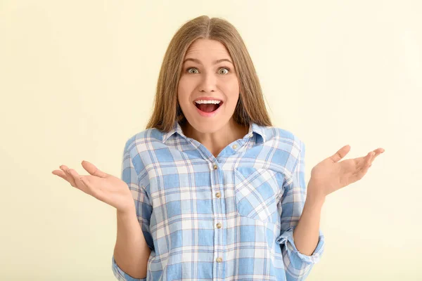 Verrast jonge vrouw op lichte achtergrond — Stockfoto