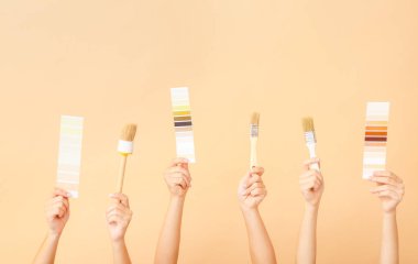 Renk arkaplanında ressam araçları olan kadın elleri