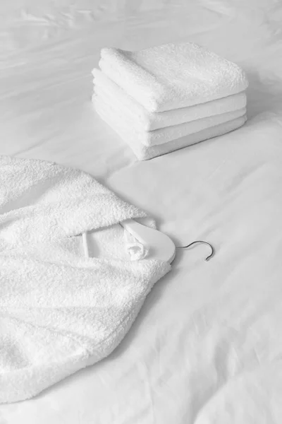 Soft clean bathrobe and towels on bed — Stock Photo, Image