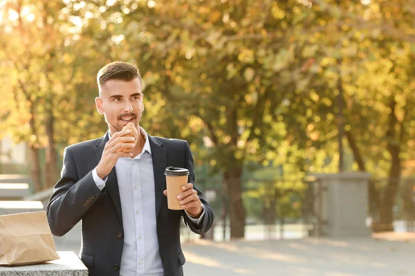 Portrait of handsome businessman having snack outdoors — Stock Photo, Image