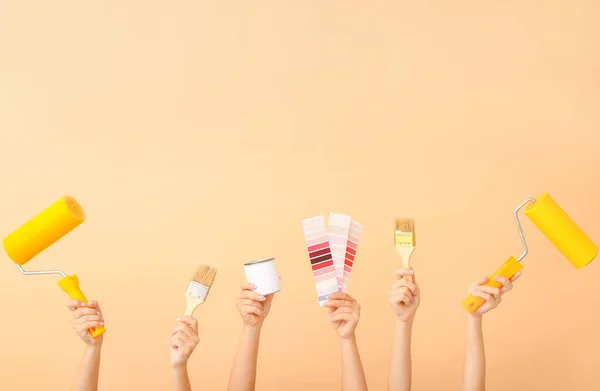 Female hands with painter's tools on color background — Stock Photo, Image