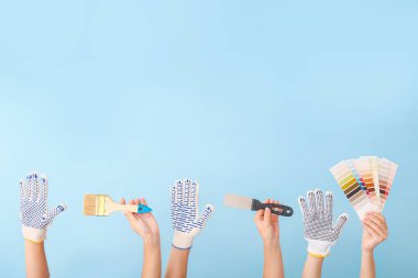 Renk arkaplanında ressam araçları olan kadın elleri