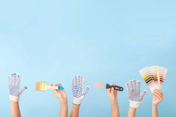 Female hands with painter's tools on color background — Stock Photo, Image