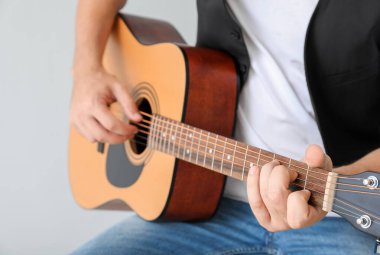 Işık arkaplanda gitar çalan adam, yakın plan
