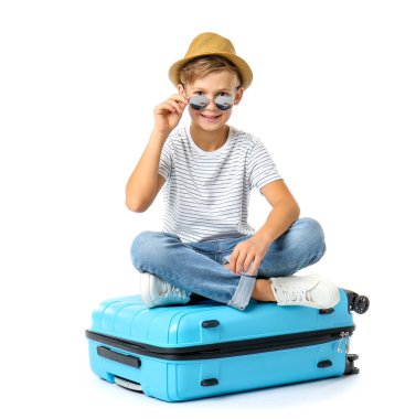 Beyaz arka planda bavulu olan şirin bir çocuk.