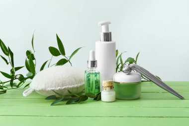 Ahşap masada yaka yaka ve masaj aletleriyle kozmetik ürünleri.