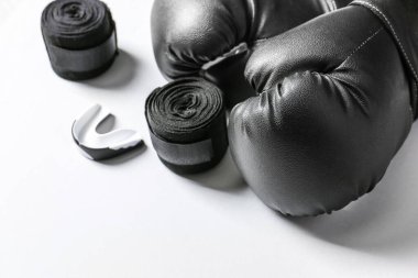 Boks eldivenleri, bileklikler ve beyaz arka planda ağız parçası.