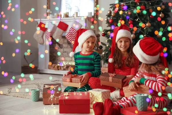 Niedliche kleine Kinder mit Weihnachtsgeschenken zu Hause — Stockfoto