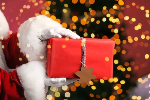 Santa Claus con regalo de Navidad sobre fondo borroso —  Fotos de Stock