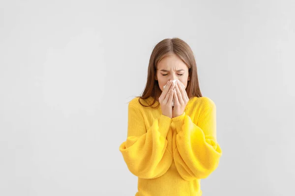 Young woman suffering from allergy on light background — 스톡 사진
