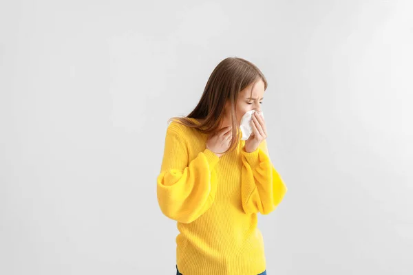 Jovem mulher que sofre de alergia em fundo claro — Fotografia de Stock