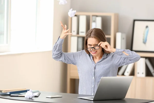 Jovem estressada à mesa no escritório — Fotografia de Stock