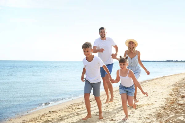 Bonne famille courir sur la plage de la mer — Photo
