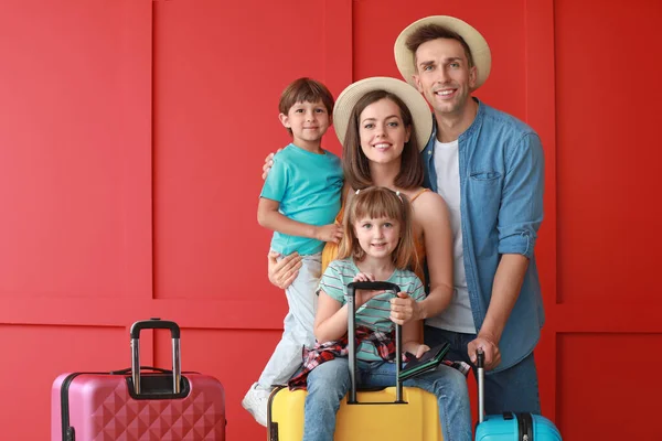 Happy family with luggage on color background — Stock Photo, Image
