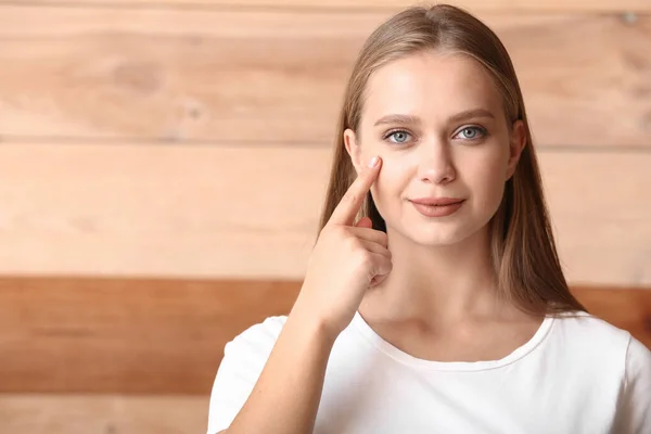 Young deaf mute woman using sign language on wooden background — Stock Photo, Image