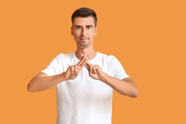 Joven hombre mudo sordo usando lenguaje de señas sobre fondo de color —  Fotos de Stock
