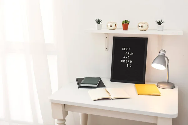 Board with motivation phrase on workplace indoors — Stock Photo, Image