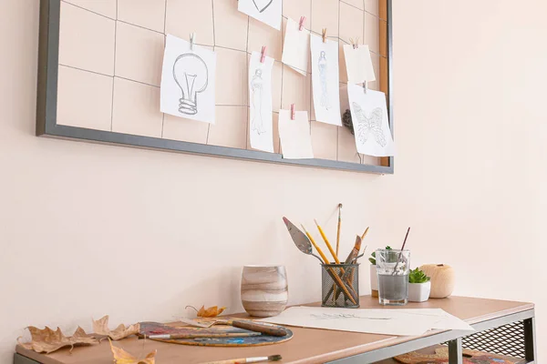 Comfortable workplace with mood board near light wall — Stockfoto